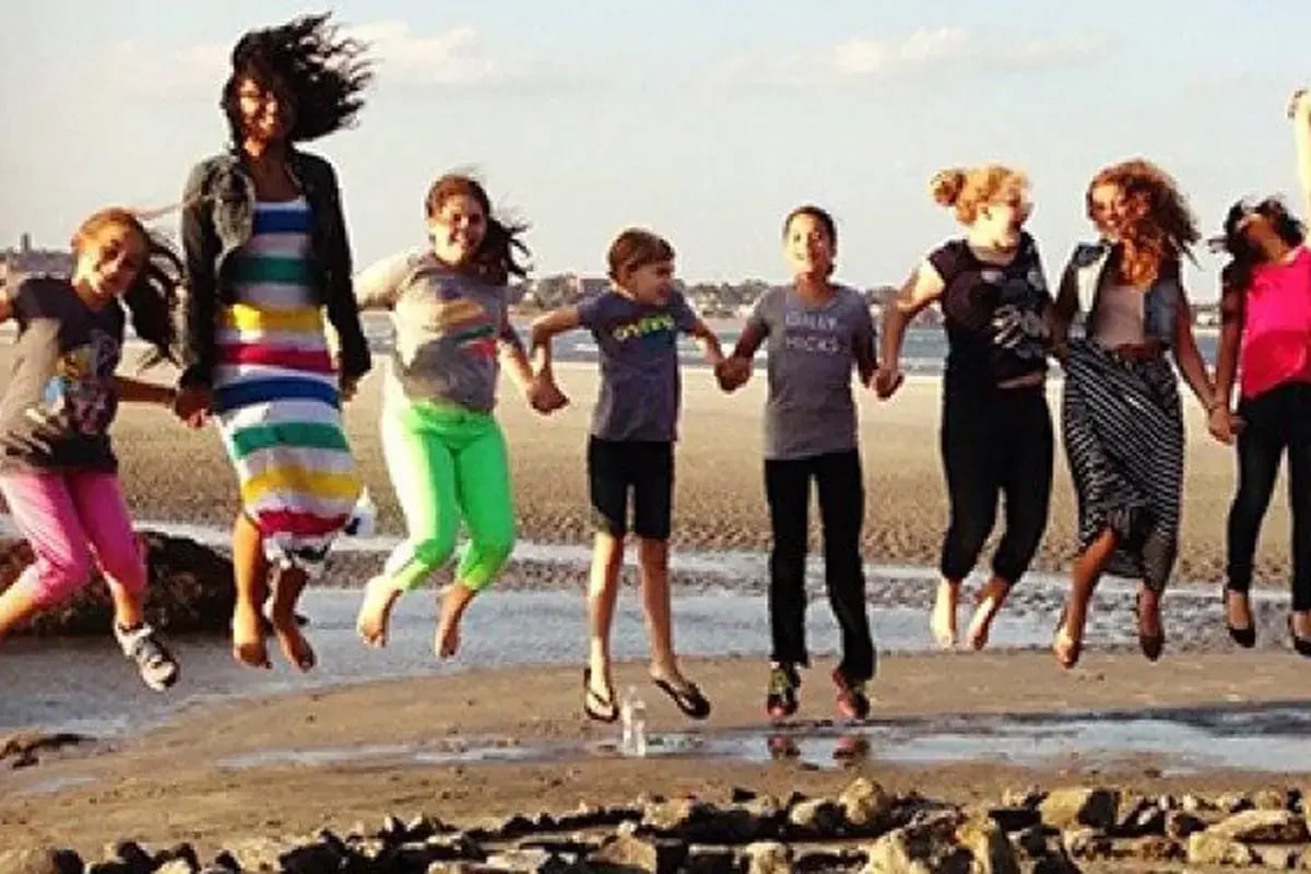 Women and girls jumping on a beach