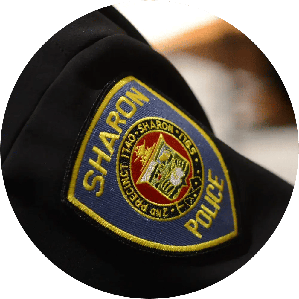 Close-up of a police badge on an officer’s uniform.