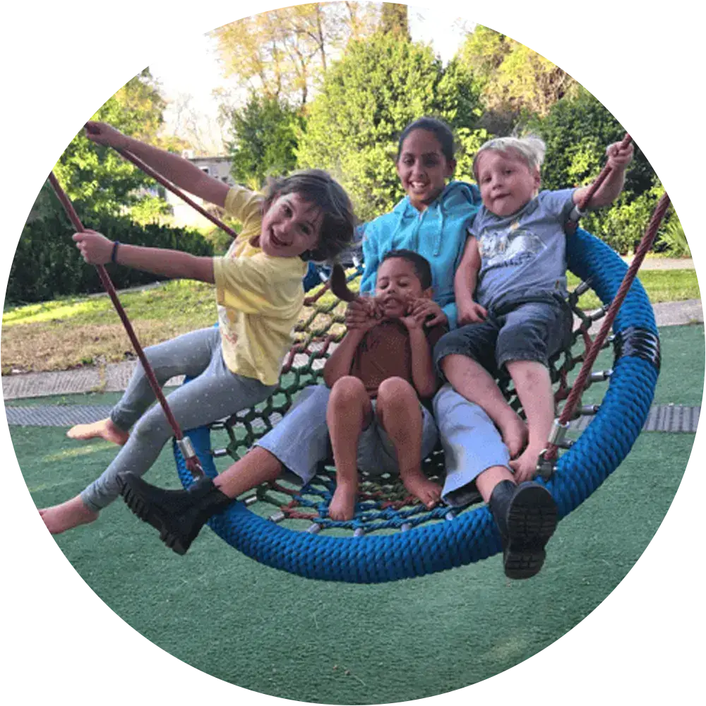 Children playing on a swing set in a community in northern Israel.